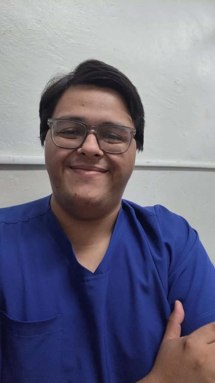 Dr. Jorge Carlos López Arceo, smiling, wearing glasses and blue scrubs.